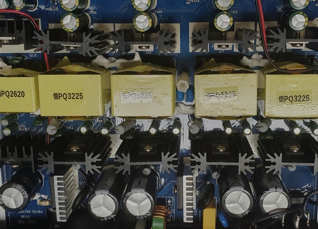 Switched-mode power stage: paralleled transformers, heatsinked switching devices and bulk capacitors.