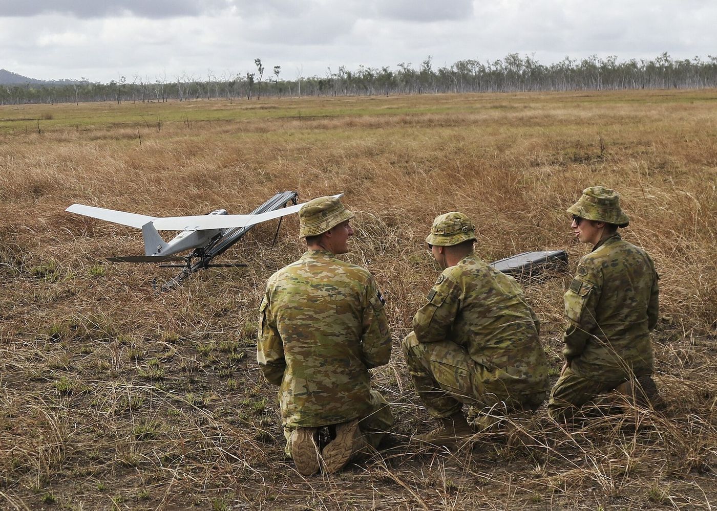 A crew preparing an unmanned aircraft for launch in open country.