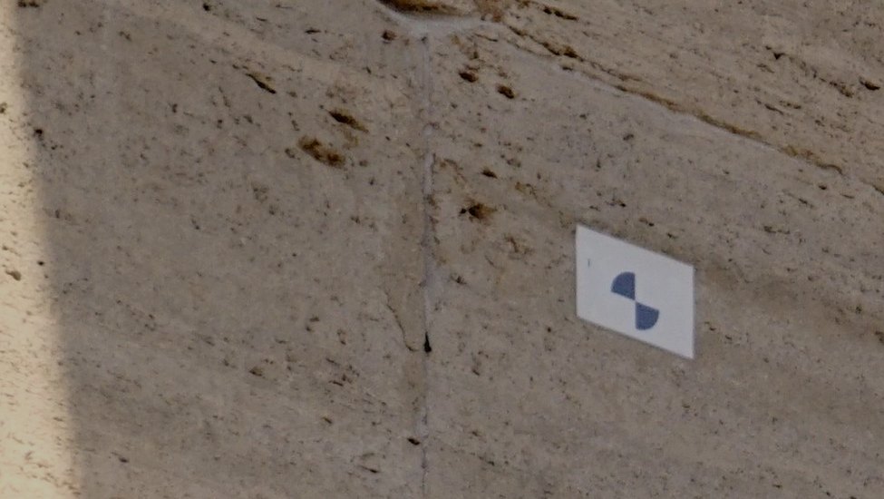 A coded fiducial target fixed to a stone structure, surveyed in as a known reference point.